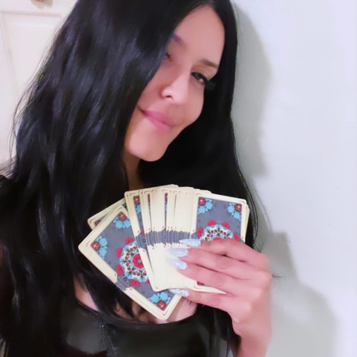 lea wolf psychic astrology medium reader holding up tarot cards